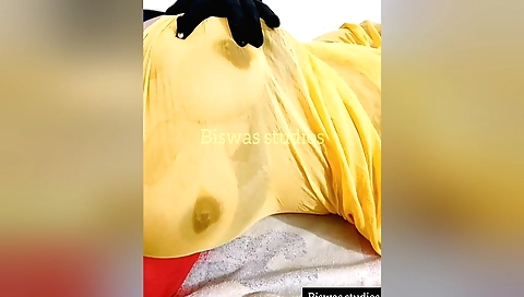 Sexy indian girl in a yellow saree playing with her hair